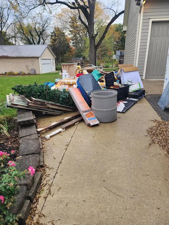 Dumpster being loaded with debris for 12 Yard Dumpster Rental in Pinehurst